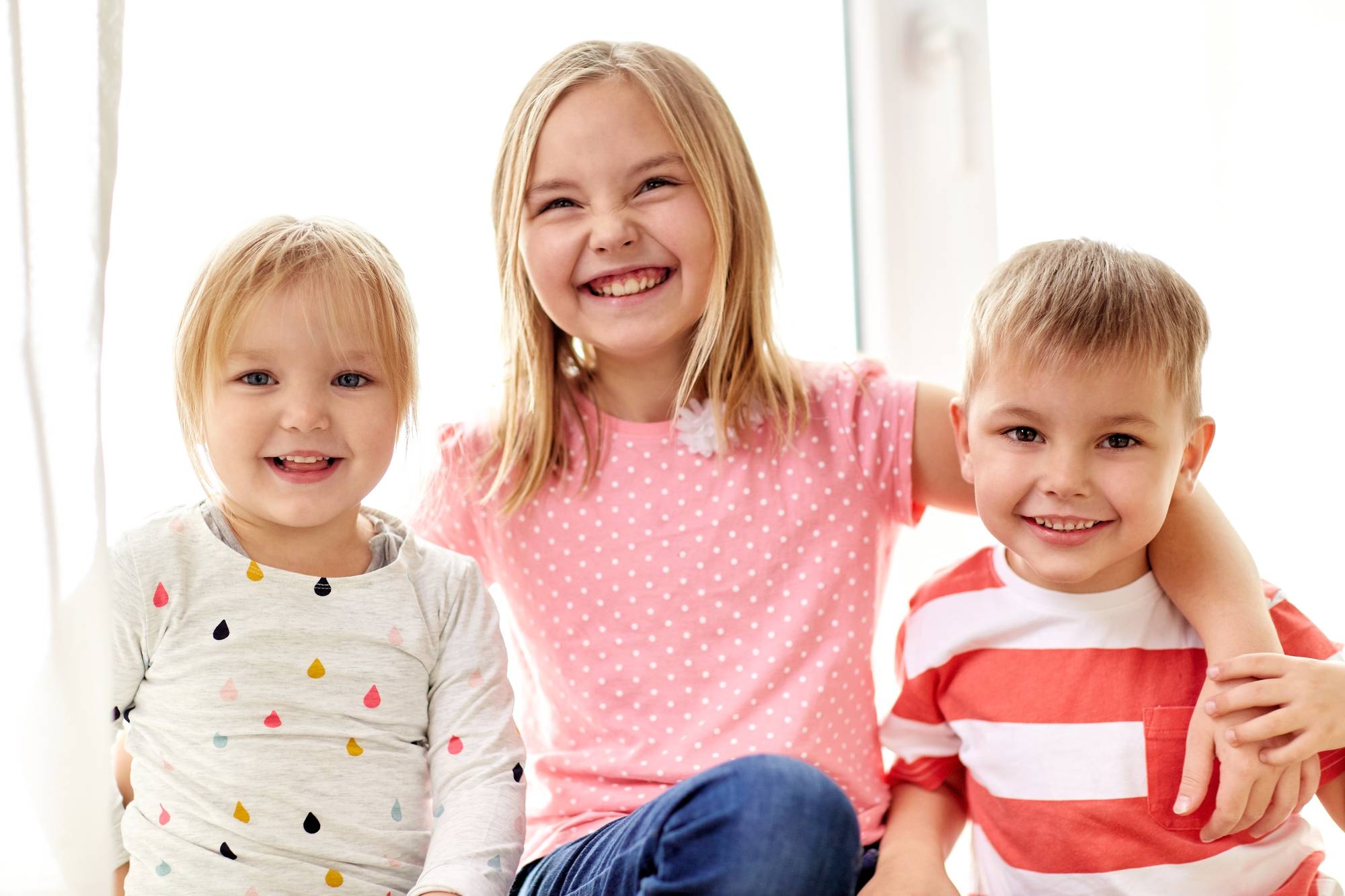 Three siblings smiling at the camera