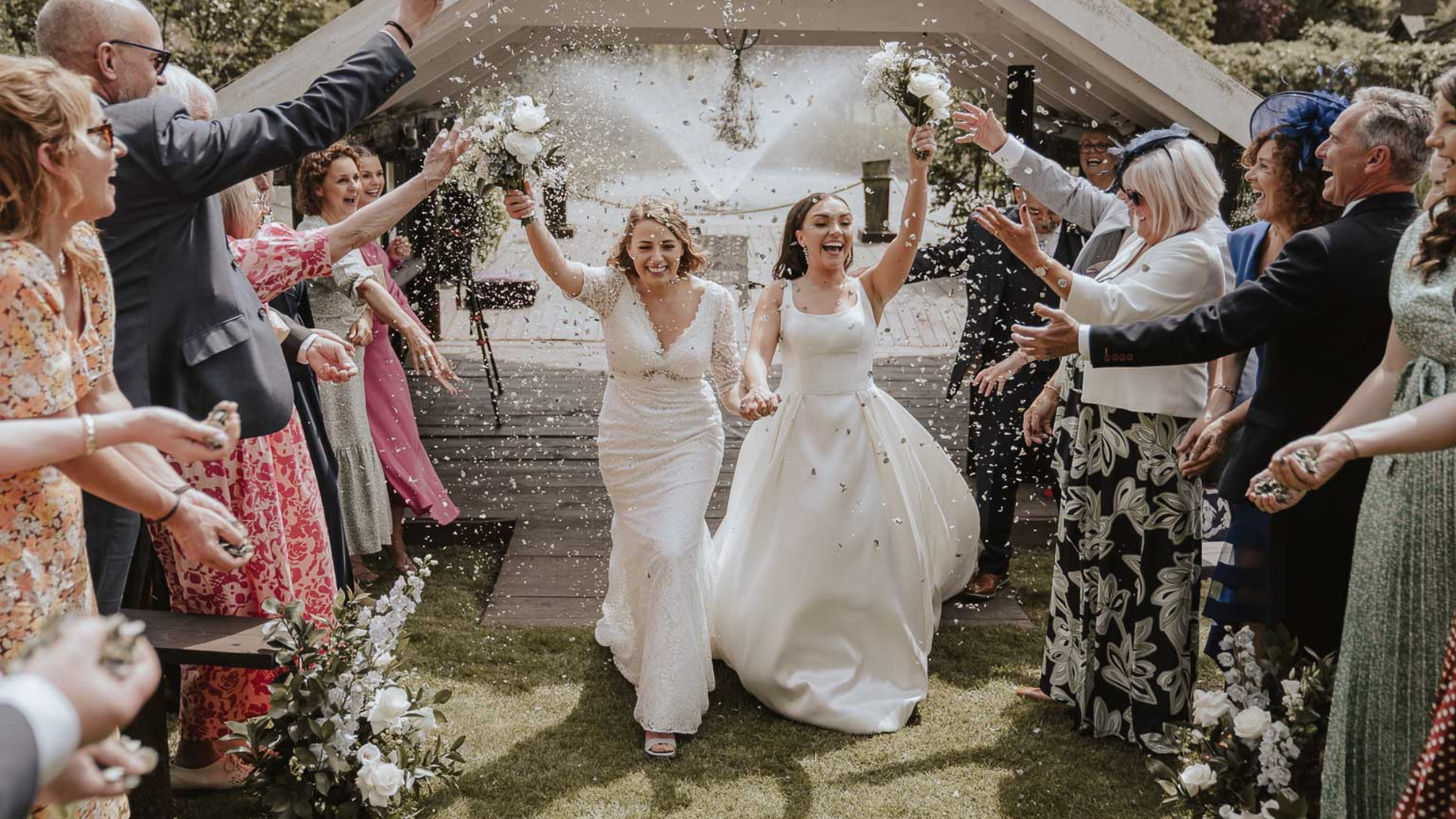 Two brides celebrating their ceremony. with their wedding party