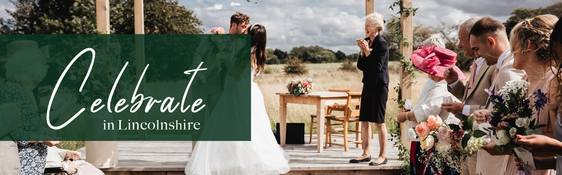 A bride and groom kissing at the alter and the registrar clapping with joy