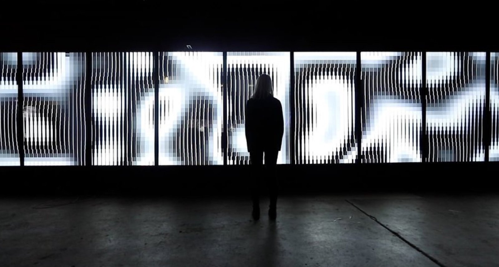 A woman stood in front a  light installation