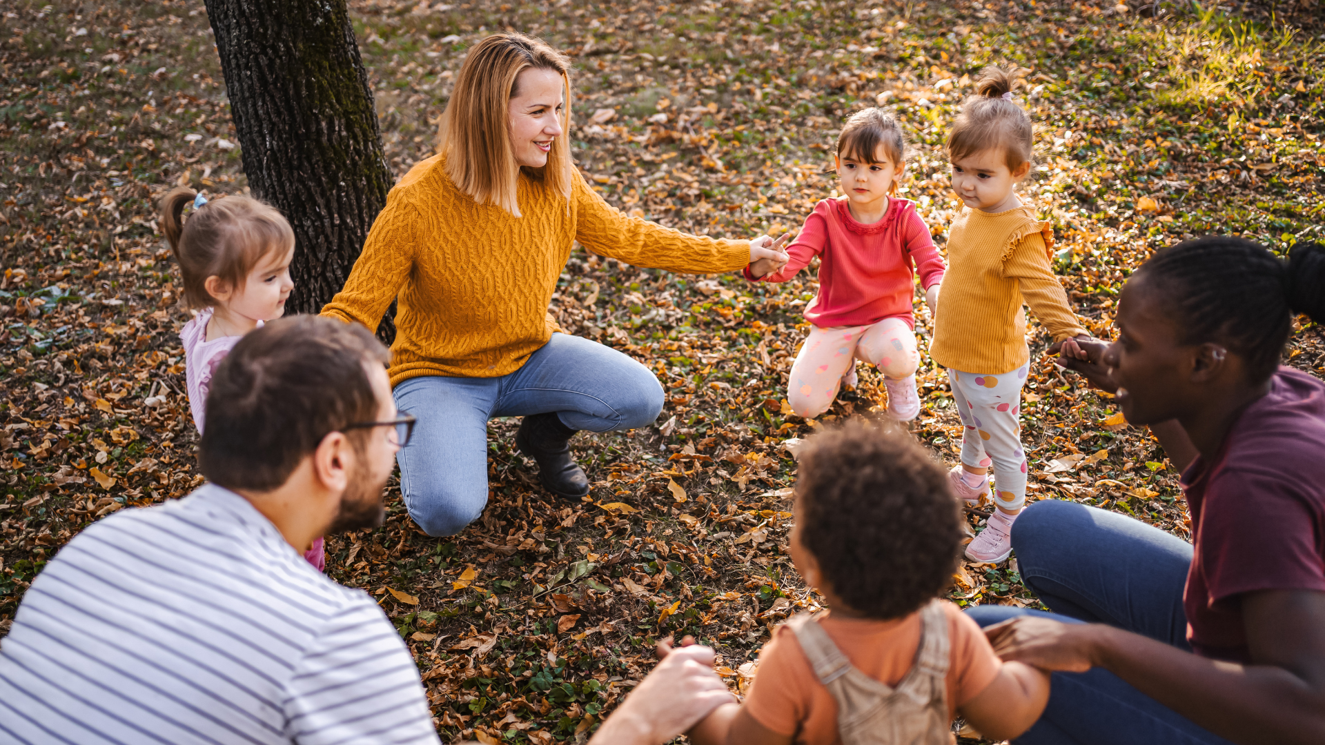 Three adults playing with children
