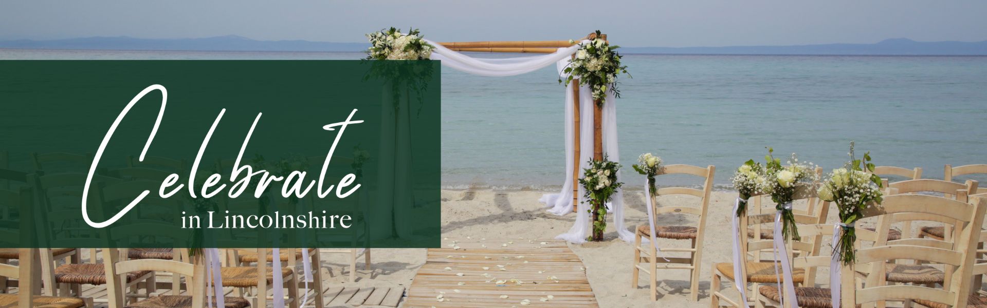 A ceremony set up on the a beach with the sea in the distance