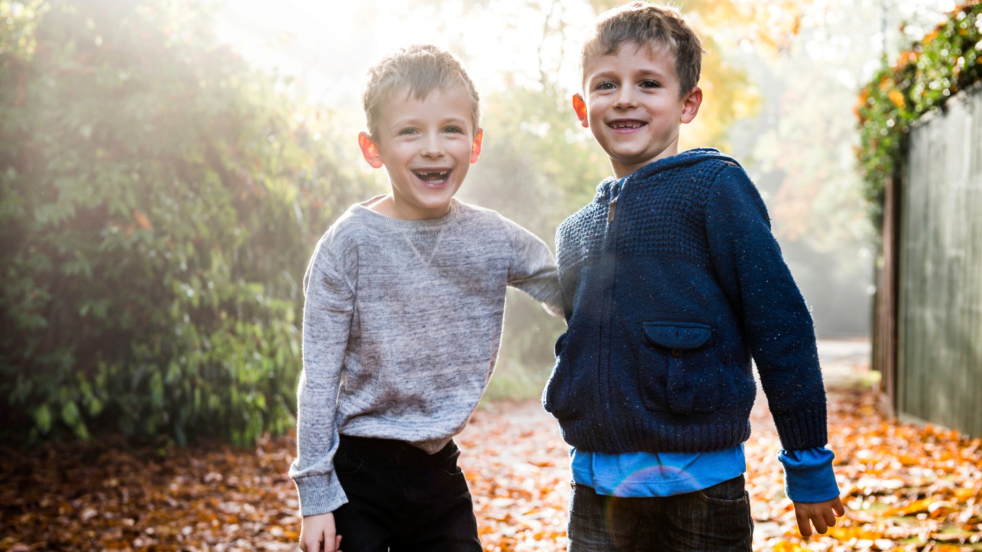 Two young boys laughing outside