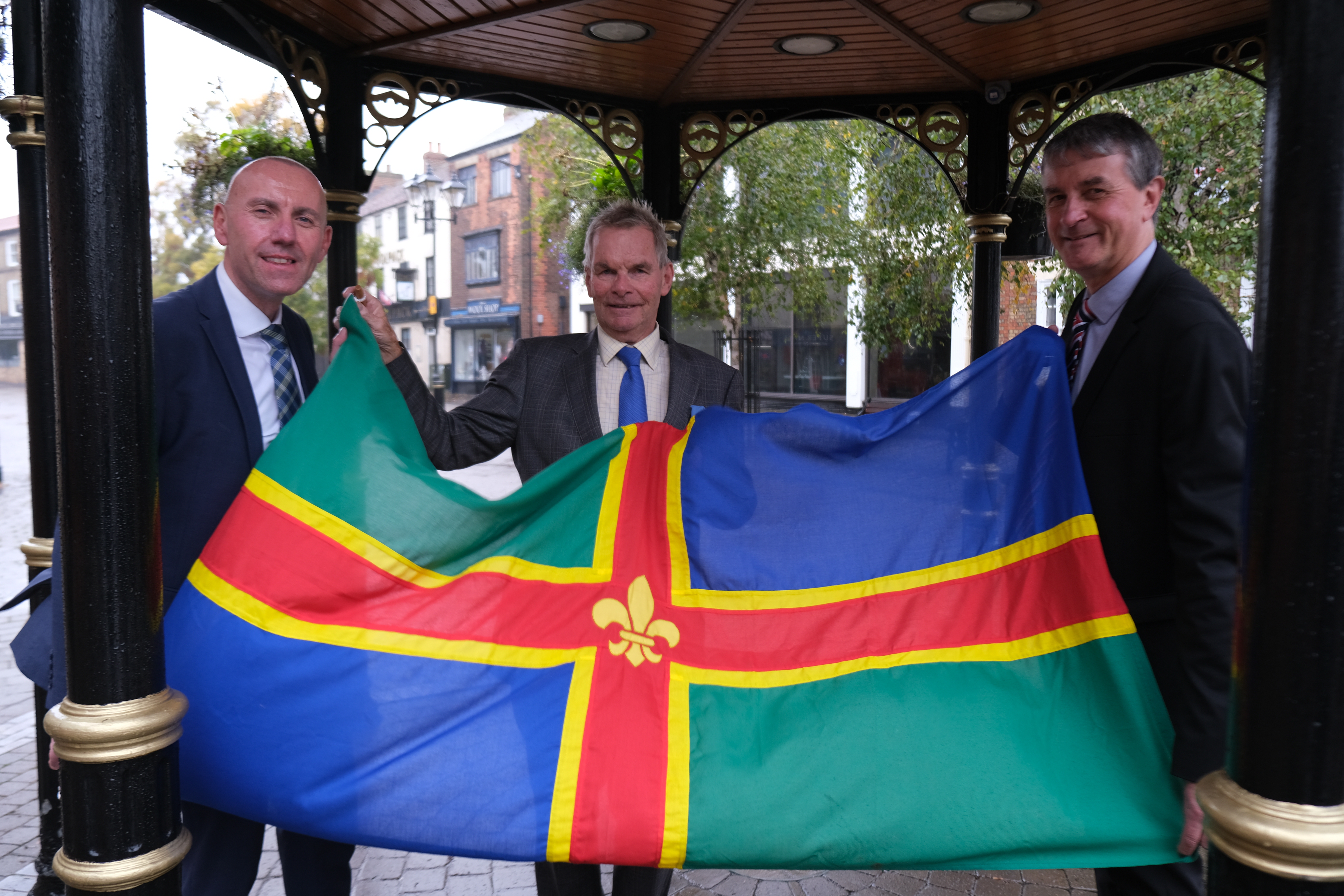 Leaders of North, North East and Lincolnshire County Council holding the Lincolnshire flag