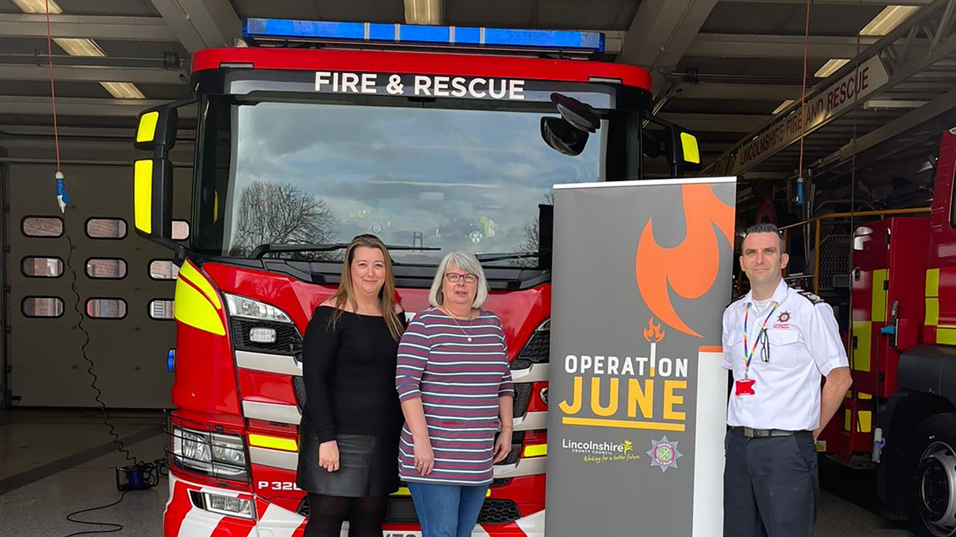 The minds behind Operation June in front of a fire engine