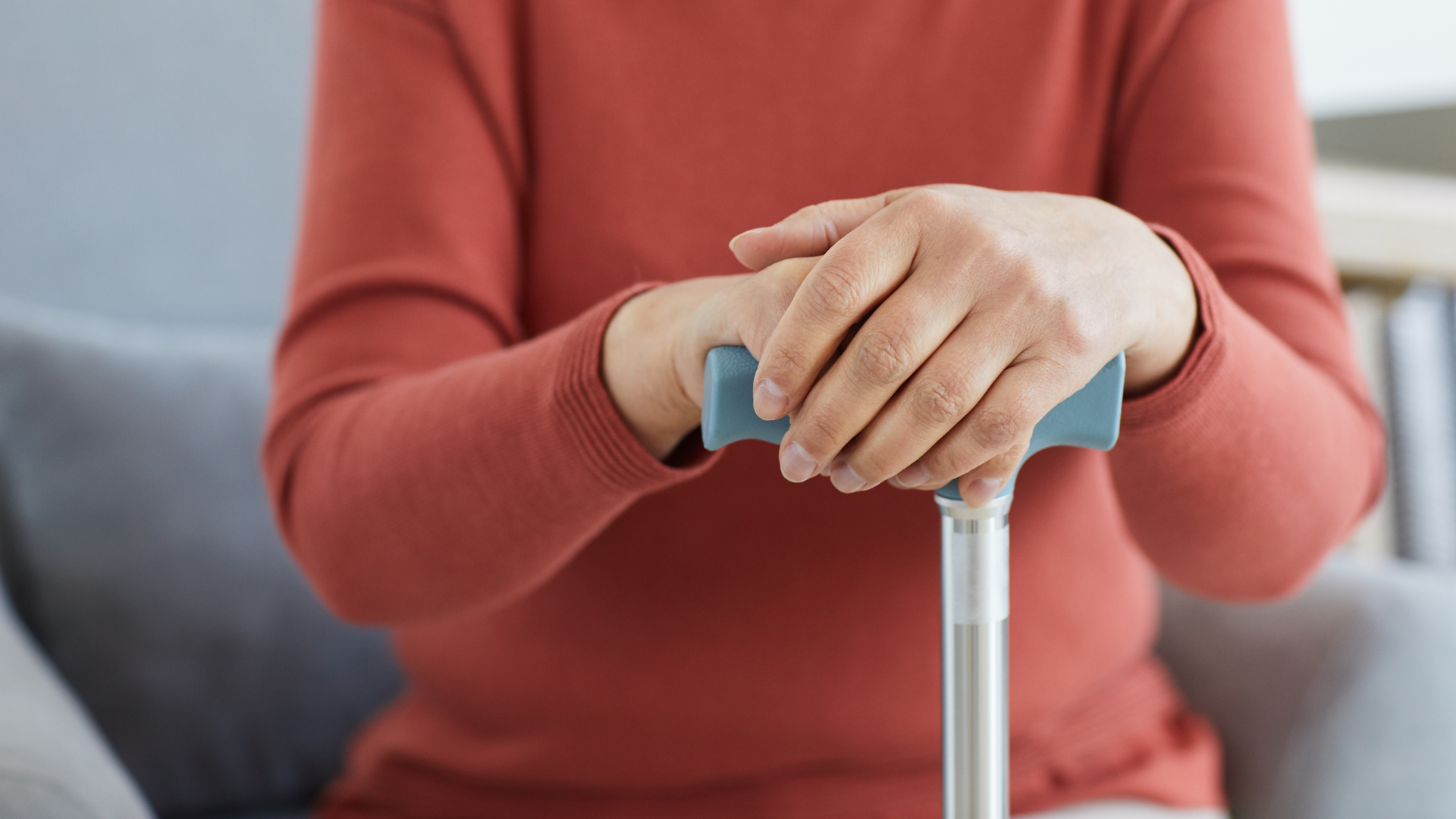 A close up of a lady holding a crutch