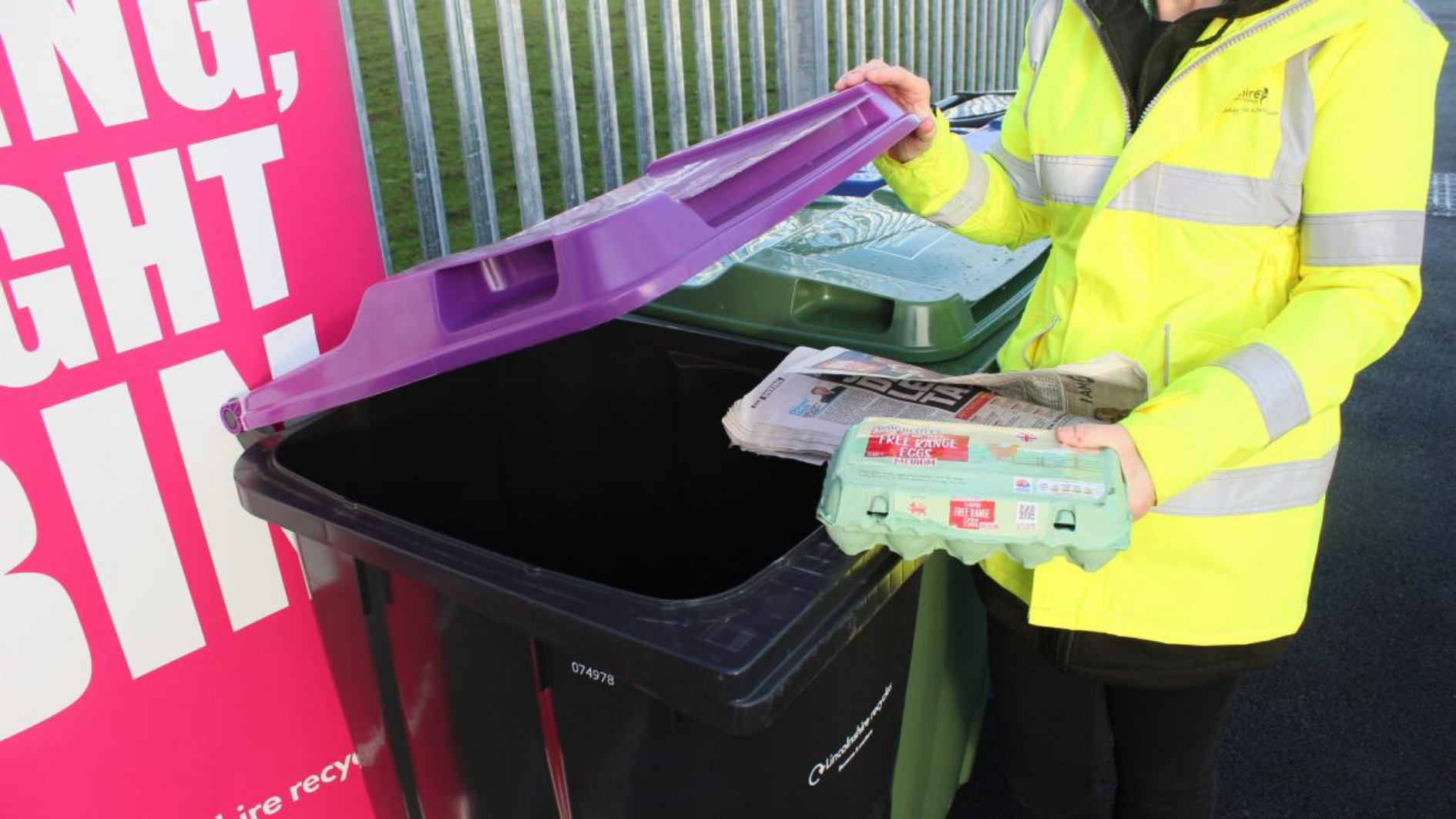 A resident puts an egg carton into a purple lidded bin