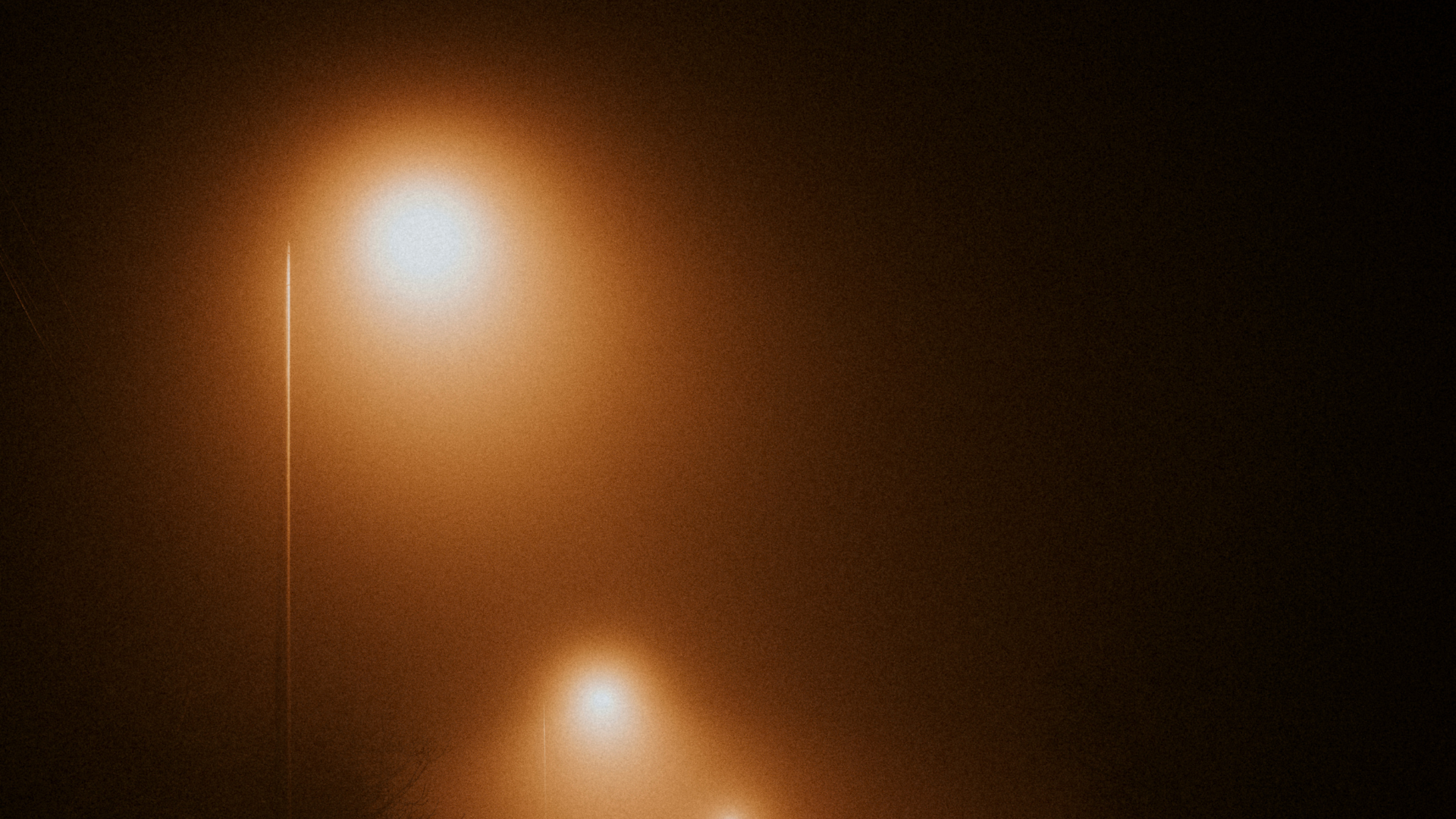 A close up of a streetlight on a misty dark evening