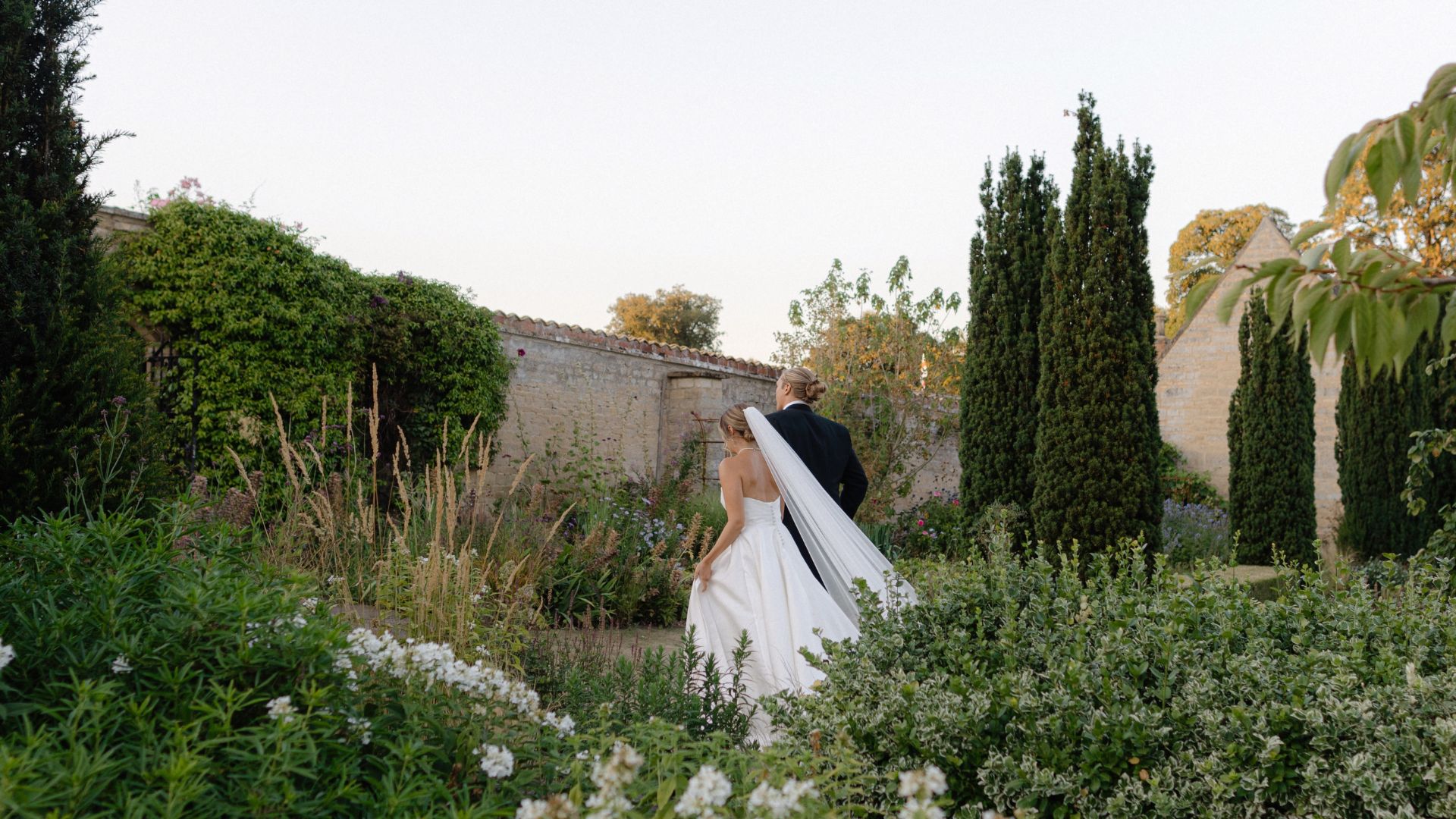 A bride and groom walking around a garden, in an old estate