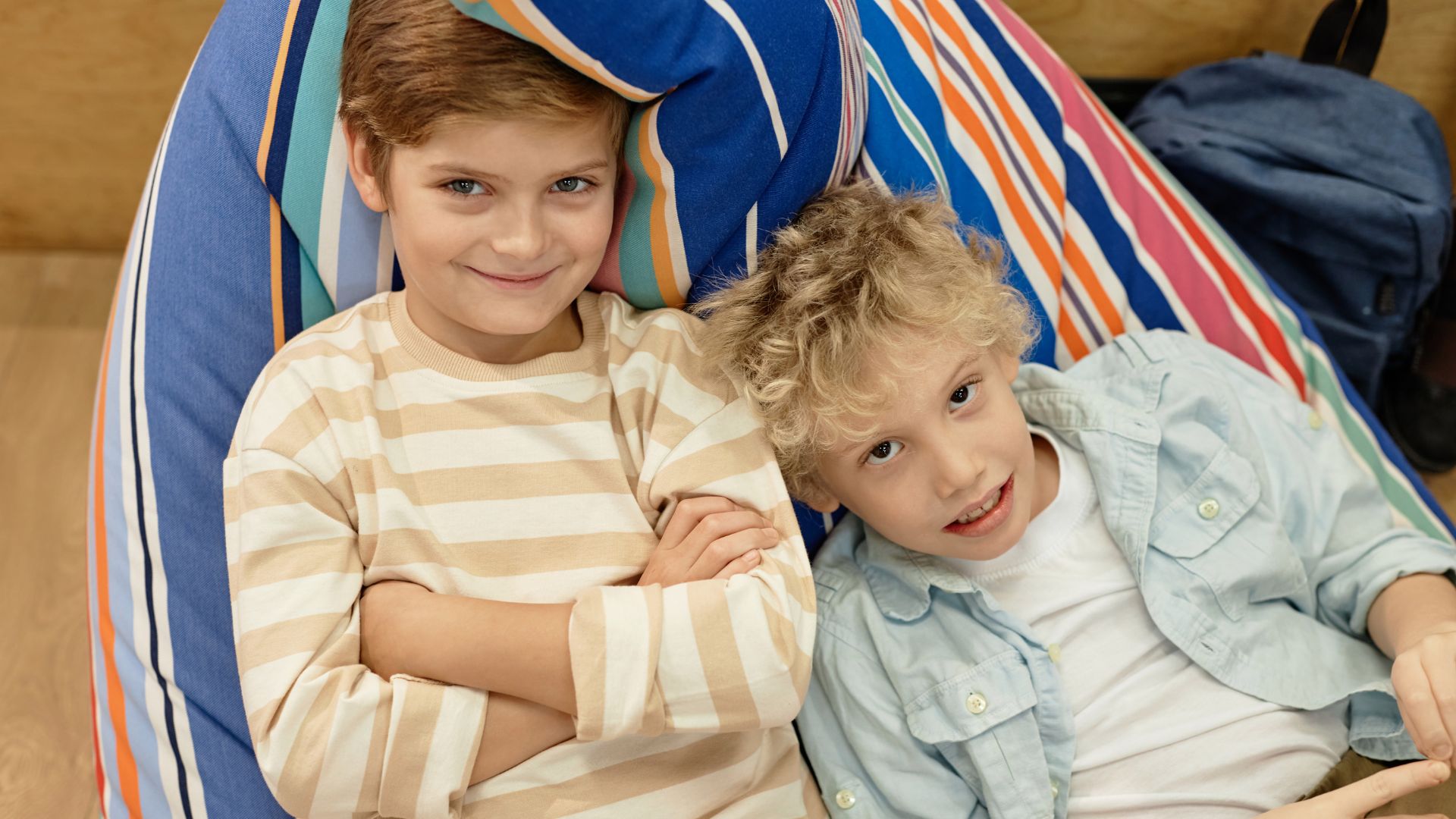 Two young boys sat on a striped bean bag